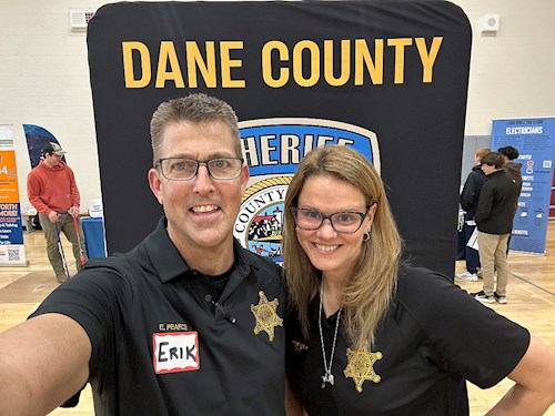 Two mentors standing in front of a DCSO banner